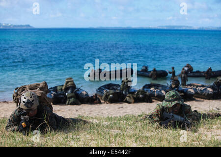 Au sol et d'autodéfense japonaise US Marine nageur scout soldats effectuer une opération spéciale d'atterrissage plage tout en pratiquant les techniques de niveau de petites unités dans le cadre du Programme d'échange d'observateur du Japon à Kin Blue Beach 16 juillet 2014 à Okinawa, au Japon. Banque D'Images