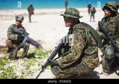 Au sol et d'autodéfense japonaise US Marine nageur scout soldats effectuer une opération spéciale d'atterrissage plage tout en pratiquant les techniques de niveau de petites unités dans le cadre du Programme d'échange d'observateur du Japon à Kin Blue Beach 16 juillet 2014 à Okinawa, au Japon. Banque D'Images