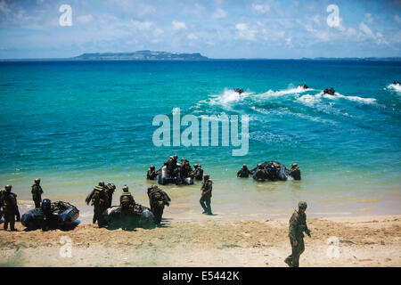 Au sol et d'autodéfense japonaise US Marine nageur scout soldats effectuer une opération spéciale d'atterrissage plage tout en pratiquant les techniques de niveau de petites unités dans le cadre du Programme d'échange d'observateur du Japon à Kin Blue Beach 16 juillet 2014 à Okinawa, au Japon. Banque D'Images