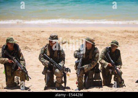 Au sol et d'autodéfense japonaise US Marine nageur scout soldats effectuer une opération spéciale d'atterrissage plage tout en pratiquant les techniques de niveau de petites unités dans le cadre du Programme d'échange d'observateur du Japon à Kin Blue Beach 16 juillet 2014 à Okinawa, au Japon. Banque D'Images