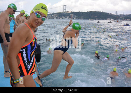 Istanbul, Turquie. 20 juillet 2014. Nageurs au début de la course du Bosphore, dans laquelle les concurrents nagent de l'Asie à l'Europe à travers la course du Bosphore. En arrière-plan le deuxième pont reliant l'Europe et l'Asie, le pont Fatih Sultan Mehmet, peut être vu, la course se termine à 6,5 km en aval juste avant le premier pont qui relie l'Europe et Aisa. Crédit : Susanne Masters/Alamy Live News Banque D'Images