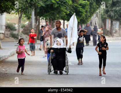 Gaza, Territoires palestiniens. 20 juillet, 2014. Les Palestiniens tiennent des drapeaux blancs, comme ils s'enfuir de leurs maisons à Al Shejaiyaa dans le quartier est de la ville de Gaza le long de la frontière entre Israël et Gaza, le 20 juillet 2014. Des dizaines de milliers de Palestiniens vivant dans la région qui est à proximité de leurs maisons de gauche au cours des jours à chercher l'abri d'une invasion terrestre israélienne. Israël a été appuyé sur son opération terrestre dans le sud de Gaza, après l'infanterie entré l'enclave côtière il y a trois jours : Crédit ZUMA Press, Inc./Alamy Live News Banque D'Images