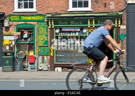 Vélo homme la boutique Quincaillerie passé à Hereford, Herefordshire, Angleterre, Royaume-Uni Banque D'Images