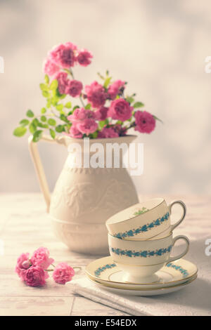 Tasses vintage avec les roses roses fraîchement cueillies du jardin - vintage tone ajouté Banque D'Images