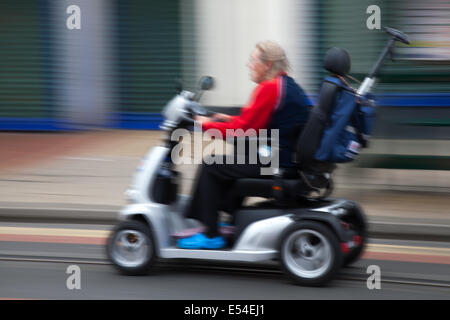 Utilisateur de fauteuil roulant à Fleetwood, Lancashire, 20 juillet, 2014. Scooter de mobilité brouillée, ou fauteuil roulant motorisé, en déplacement à la Fête des transports 5000. Cet événement a eu lieu pour la première fois le 14 juillet 1985, et depuis, est devenu une institution, 5000. Banque D'Images
