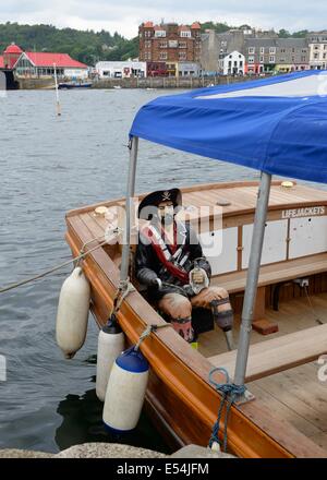 Les passagers d'un voyage sur le bateau 'Purple heather' sont accompagnés par cette vie de pirate taille figure. Banque D'Images