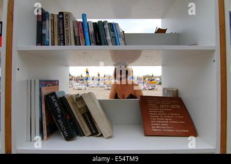 Varna, BGR. 20 juillet, 2014. Les gens recherchent et lire des livres à la première bibliothèque de plage ouvert en Bulgarie à la mer Noire d'Albena Resort, Dimanche, juillet, 20, 2014. En Albena a ouvert la première bibliothèque de plage dans l'Union européenne et la troisième dans le monde et sur ses tablettes sont disposés plus de 2500 volumes dans plus de 10 langues. La bibliothèque est totalement gratuit. Les titres sont soigneusement sélectionnés pour tous les goûts - world classics, suspense, mystère, lectures, romantique mémoires. Les touristes pourront prendre un livre pour libre sans une carte de bibliothèque. Si ils n'ont pas lu le livre qu'ils ont prises, Banque D'Images