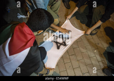 Istanbul, Turquie. 20 juillet, 2014. Les garçons font un drapeau israélien sur un t-shirt déchiré et de pulvérisation de peinture afin de le graver dans du consulat d'Israël. Des milliers de personnes appelant à la fin de la guerre se sont réunis à Istanbul le 19 juillet 2014. Photo par Jodi Hilton/NurPhoto Crédit : Jodi Hilton/NurPhoto/ZUMA/Alamy Fil Live News Banque D'Images