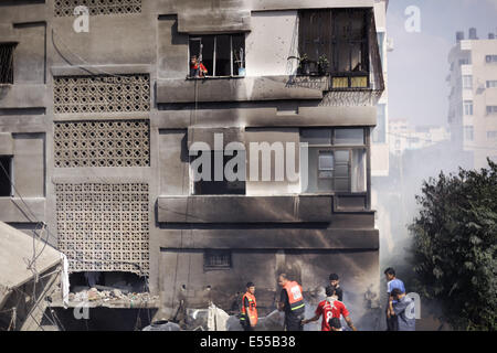 La bande de Gaza. 21 juillet, 2014. Les pompiers essaient d'éteindre un feu dans une des maisons que les avions ont bombardé après l'armée de l'air israélienne maison appartenant à un membre du Hamas dans le camp de réfugiés de Shati après qu'il a été lancé par trois roquettes et des avions israéliens ont bombardé plusieurs cibles dans la bande de Gaza, le lundi, tuant 40 Palestiniens, dont des enfants, ce qui porte le nombre de Palestiniens tués depuis le début de l'offensive sur Gaza à 560 morts et plus de 5 000 blessés et 1 100 maisons détruites. Credit : Ibrahim Khader/Pacific Press/Alamy Live News Banque D'Images