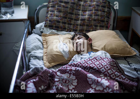 La bande de Gaza. 21 juillet, 2014. Enfant blessé durant les frappes aériennes et de repos en attente de décoller loin de Beit Hannoun pour une école de l'ONU à Cheikh a dit qu'ils étaient des centaines de personnes sont à l'abri des bombardements. Fuir les Palestiniens le Beit Hannoun voisinage pendant les bombardements israéliens dans la bande de Gaza, Territoires palestiniens. Credit : Ibrahim Khader/Pacific Press/Alamy Live News Banque D'Images