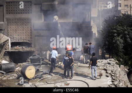 La bande de Gaza. 21 juillet, 2014. Les pompiers essaient d'éteindre un feu dans une des maisons que les avions ont bombardé après l'armée de l'air israélienne maison appartenant à un membre du Hamas dans le camp de réfugiés de Shati après qu'il a été lancé par trois roquettes et des avions israéliens ont bombardé plusieurs cibles dans la bande de Gaza, le lundi, tuant 40 Palestiniens, dont des enfants, ce qui porte le nombre de Palestiniens tués depuis le début de l'offensive sur Gaza à 560 morts et plus de 5 000 blessés et 1 100 maisons détruites. Credit : PACIFIC PRESS/Alamy Live News Banque D'Images