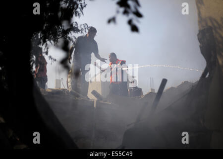 La bande de Gaza. 21 juillet, 2014. Les pompiers essaient d'éteindre un feu dans une des maisons que les avions ont bombardé après l'armée de l'air israélienne maison appartenant à un membre du Hamas dans le camp de réfugiés de Shati après qu'il a été lancé par trois roquettes et des avions israéliens ont bombardé plusieurs cibles dans la bande de Gaza, le lundi, tuant 40 Palestiniens, dont des enfants, ce qui porte le nombre de Palestiniens tués depuis le début de l'offensive sur Gaza à 560 morts et plus de 5 000 blessés et 1 100 maisons détruites. Credit : PACIFIC PRESS/Alamy Live News Banque D'Images