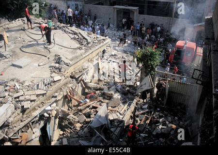 La bande de Gaza. 21 juillet, 2014. Les pompiers essaient d'éteindre un feu dans une des maisons que les avions ont bombardé après l'armée de l'air israélienne maison appartenant à un membre du Hamas dans le camp de réfugiés de Shati après qu'il a été lancé par trois roquettes et des avions israéliens ont bombardé plusieurs cibles dans la bande de Gaza, le lundi, tuant 40 Palestiniens, dont des enfants, ce qui porte le nombre de Palestiniens tués depuis le début de l'offensive sur Gaza à 560 morts et plus de 5 000 blessés et 1 100 maisons détruites. Credit : PACIFIC PRESS/Alamy Live News Banque D'Images