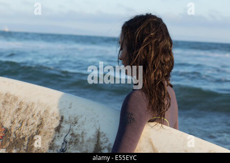 Surfer avec des femmes exerçant à titre surfboad wetsuit ocean Banque D'Images