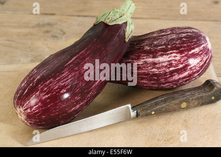 Deux aubergines violet et blanc ou d'aubergines sur une planche en bois Banque D'Images