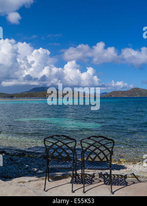 Deux chaises vides sur la plage au bord de l'eau de Coral Bay sur l'île des Caraïbes de St John dans les îles Vierges américaines Banque D'Images