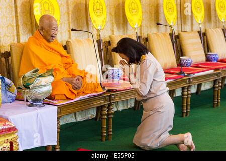 Bangkok, Thaïlande. 22 juillet 2014.Un fonctionnaire thaïlandais s'incline devant un moine bouddhiste à Sanam Luang. Des centaines de militaires thaïlandais officiers et fonctionnaires ont assisté à un service de chants bouddhistes et le mérite de faire de la cérémonie pour marquer le 2ème mois anniversaire du 22 mai coup d'État qui a déposé le gouvernement civil élu et s'est terminé près de six mois, parfois violents, des manifestations anti-gouvernementales. Credit : ZUMA Press, Inc./Alamy Live News Banque D'Images