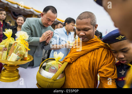 Bangkok, Thaïlande. 22 juillet, 2014.Un homme fait mérite en présentant l'aumône à un moine bouddhiste au cours d'une cérémonie qui mérite à Sanam Luang. Des centaines de militaires thaïlandais officiers et fonctionnaires ont assisté à un service de chants bouddhistes et le mérite de faire de la cérémonie pour marquer le 2ème mois anniversaire du 22 mai coup d'État qui a déposé le gouvernement civil élu et s'est terminé près de six mois, parfois violents, des manifestations anti-gouvernementales. Credit : ZUMA Press, Inc./Alamy Live News Banque D'Images