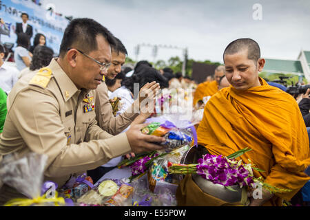 Bangkok, Thaïlande. 22 juillet 2014.Les responsables thaïlandais faire mérite en présentant l'aumône aux moines Buddhis lors d'une cérémonie qui mérite à Sanam Luang. Des centaines de militaires thaïlandais officiers et fonctionnaires ont assisté à un service de chants bouddhistes et le mérite de faire de la cérémonie pour marquer le 2ème mois anniversaire du 22 mai coup d'État qui a déposé le gouvernement civil élu et s'est terminé près de six mois, parfois violents, des manifestations anti-gouvernementales. Credit : ZUMA Press, Inc./Alamy Live News Banque D'Images