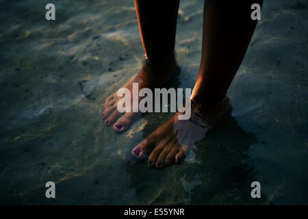 Femme debout pieds nus dans l'eau Banque D'Images