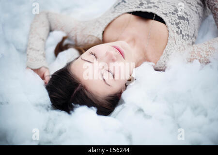 Jeune femme couchée sur des boules de coton Banque D'Images