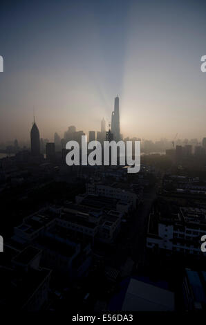 Vue panoramique en grand angle de l'horizon silhouetté du quartier financier de Lujiazui et Pudong avec la tour Jinmao et Shanghai vue contre la lumière orange du soleil levant sur un ciel bleu clair. © Olli Geibel Banque D'Images