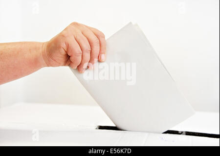 Close up of a woman's hand mettant son vote dans l'urne Banque D'Images