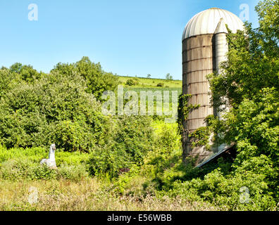 Metal cheval dans un champ près de l'ancien silo abandonné Banque D'Images