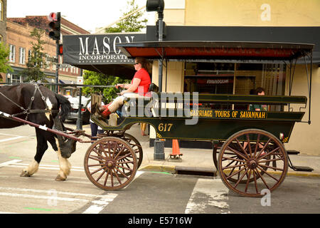 Une calèche pour visiter traverse touristiques Broughton et Jefferson rues de centre-ville historique de Savannah, GA, États-Unis d'Amérique Banque D'Images