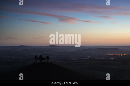 Beau lever de l'aube paysage de campagne avec vue sur la ville illuminée dans la vallée ci-dessous Banque D'Images