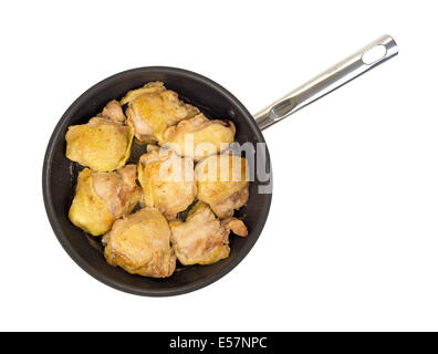 Vue du haut de cuisses de poulet cuit dans une grande poêle sur un fond blanc. Banque D'Images