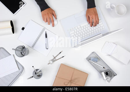 High angle shot d'une femme travaillant à partir de son bureau à domicile. Seules ses mains sont visibles comme elle tape sur son ordinateur portable. L'esprit Banque D'Images