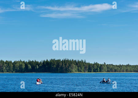 Deux canoës avec les canoéistes sur le lac Asnen, Smaland, Suède Banque D'Images