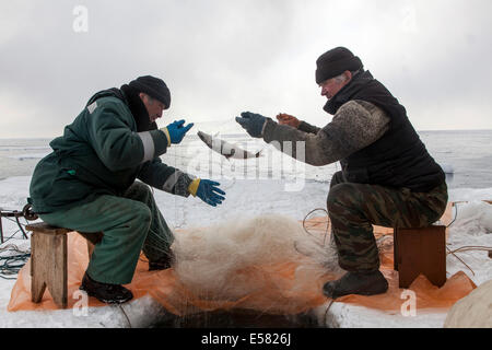 Deux personnes âgées de pêche Les pêcheurs sur le Lac Baïkal gelé, Bolschoje Goloustnoje, région du lac Baïkal, Sibérie, Russie Banque D'Images