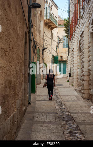 Une femme marche dans une ruelle dans la vieille ville de Nazareth, Israël. Banque D'Images