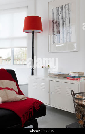 Lampe rouge et couverture avec bahut en Beach house, Sandways, Camber Sands, au Royaume-Uni. Banque D'Images