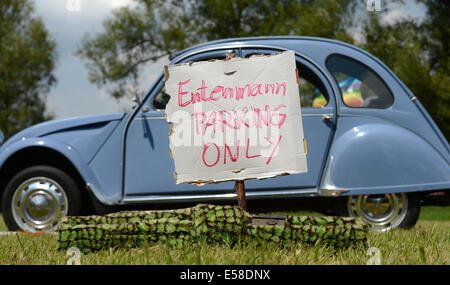 Hofheim-Diedenbergen, Allemagne. 23 juillet, 2014. Entenmann 'uniquement' parking (Ente  = canard, surnom allemand pour Citroen 2CV) est écrit sur un panneau avant d'une Citroën 2CV à la 6e Allemagne réunion des amis de la 2CV à Hofheim-Diedenbergen, Allemagne, 23 juillet 2014. Plus de 1 000 fans de la voiture culte français et environ 700 voitures sont attendus à la réunion. Photo : Arne Dedert/dpa/Alamy Live News Banque D'Images