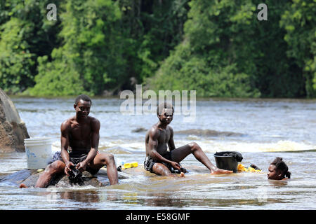 Les garçons s'en laver les vêtements dans la rivière du Suriname, du Suriname, de l'Amérique latine Banque D'Images