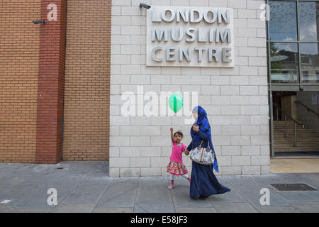 Femme musulmane et de l'enfant passent par le centre musulman de Londres, East London Mosque sur Whitechapel Road, Banque D'Images