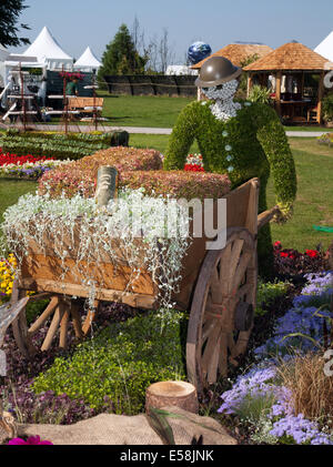 Cercueil en temps de guerre sur chariot de ferme (hearse), figurine de jardin, portant chapeau d'étain, roue d'une ancienne charrette de ferme à Tatton Park, Manchester, Royaume-Uni.23 juillet 2014.Médaille d'argent dorée par le conseil municipal de Birmingham à l'événement sur le thème du carnaval RHS - Royal Horticultural Society à Tatton Park. Banque D'Images