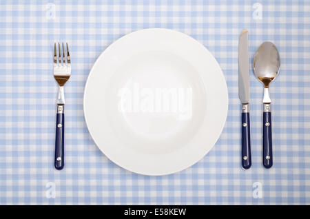 Couvrir avec couteaux, fourchettes, cuillères à carreaux et la plaque , tapis de table dans un restaurant. Banque D'Images