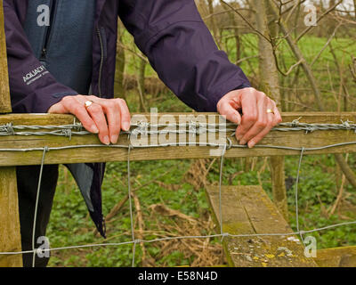 Stile avec du fil de fer barbelé fixé sur le côté de la rampe supérieure prêt à couper les doigts et les mains. Banque D'Images