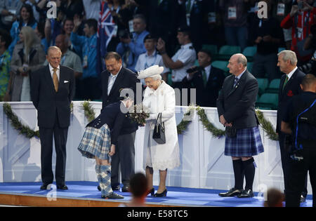 Glasgow, Ecosse, Royaume-Uni. 23 juillet, 2014. La Grande-Bretagne La reine Elizabeth II reçoit des fleurs d'un enfant au cours de la cérémonie d'ouverture des XX Jeux du Commonwealth au Celtic Park à Glasgow le 23 juillet 2014. Credit : Wang Lili/Xinhua/Alamy Live News Banque D'Images