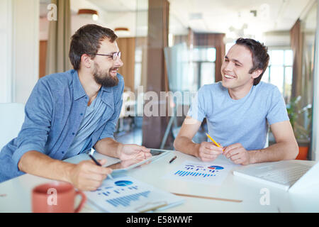 Image de deux jeunes hommes d'interaction at meeting in office Banque D'Images