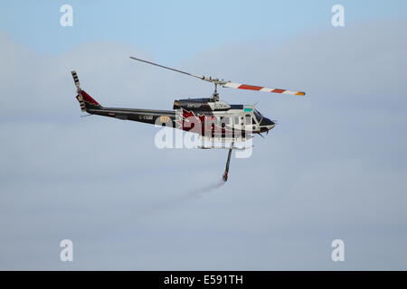 Lutte contre l'incendie aérienne un feu de brousse à l'aide d'hélicoptère bombardier d'eau dans l'ouest de l'Australie. Banque D'Images