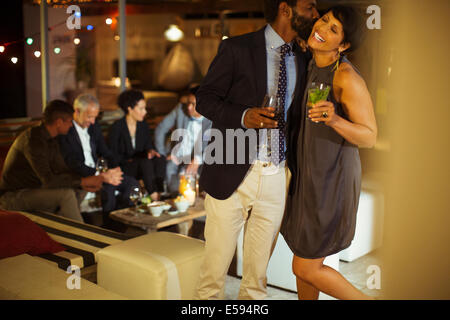 Couple kissing at party Banque D'Images