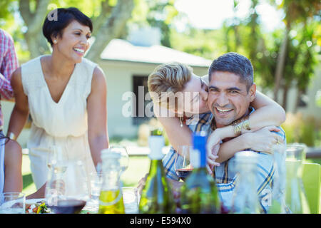 Couple kissing at table outdoors Banque D'Images
