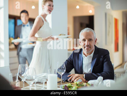 Man smiling at table at dinner party Banque D'Images