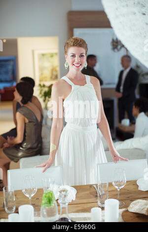 Femme debout à la table at party Banque D'Images