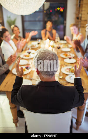 Les amis applaudir at dinner party Banque D'Images